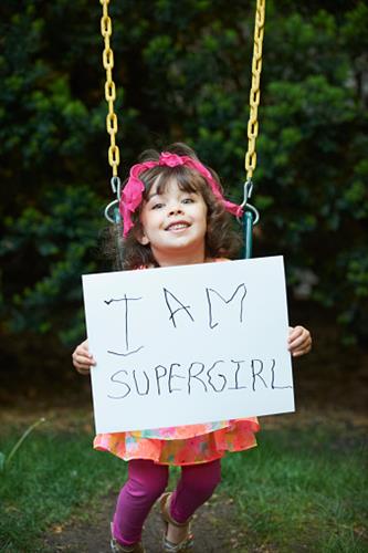 super girl needs braces orthodontist holding sign.