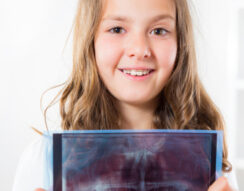 Young girl with dental braces showing x-ray of teeth for orthodontic emergency