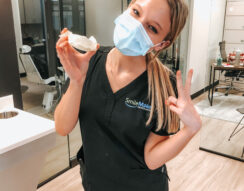 A person wearing a mask and holding a dental model
