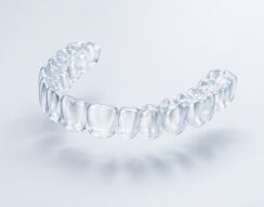 A transparent clear-aligner tray on a light background